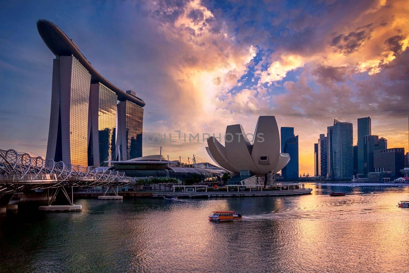 Sunset over The Helix bridge, Marina Bay Sands and Art Science museum with downtown in background, Singapore