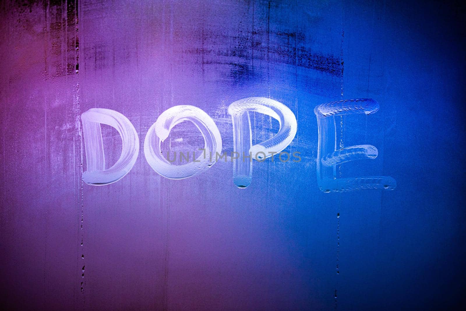 word dope handwritten on night wet window glass surface close-up with selective focus