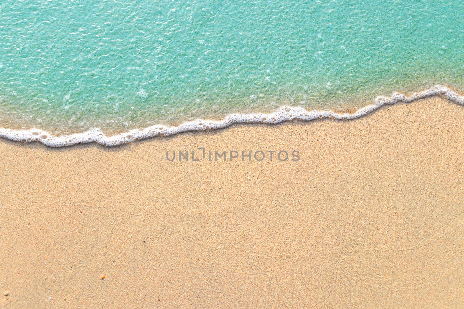 Soft waves with foam of blue ocean on the sandy beach by kaisorn