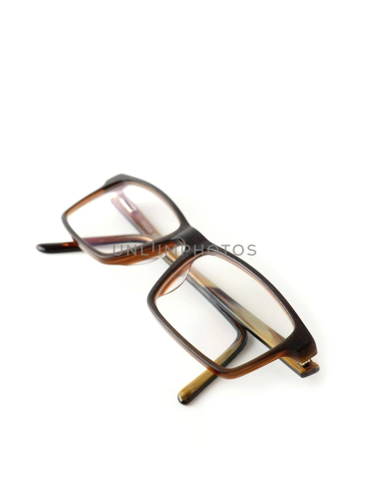 Closeup of folded brown modern eyeglasses on white background.