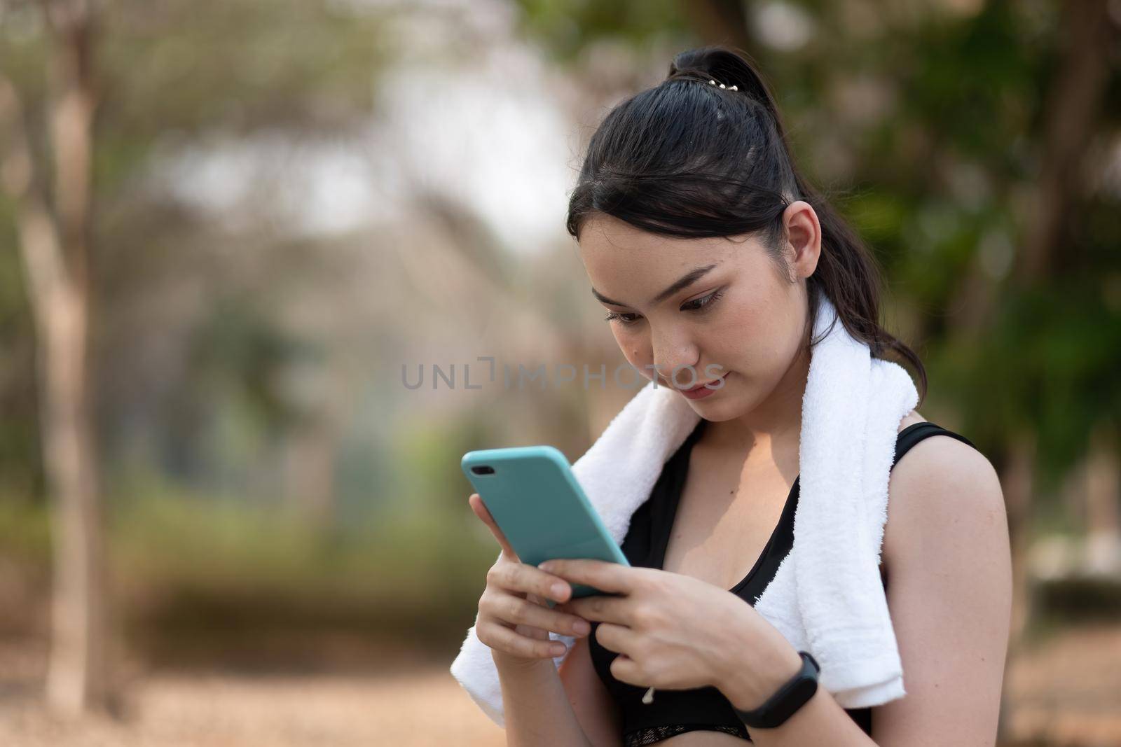 female athlete use smartphone waiting for training.