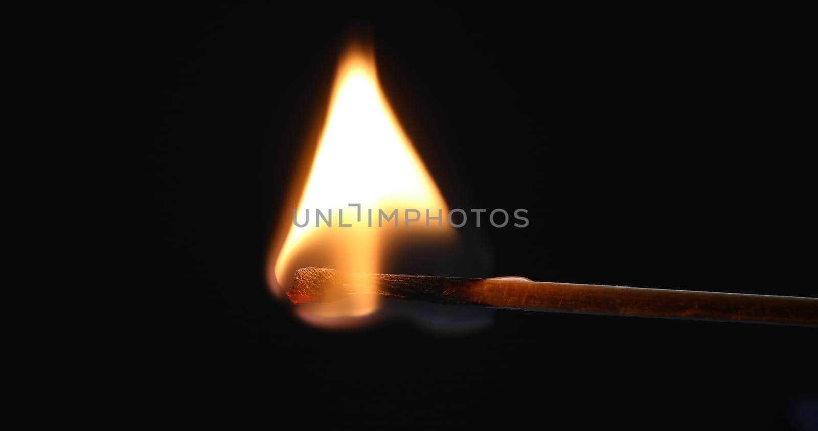 Matchstick burns with a flame and bends upward blackening