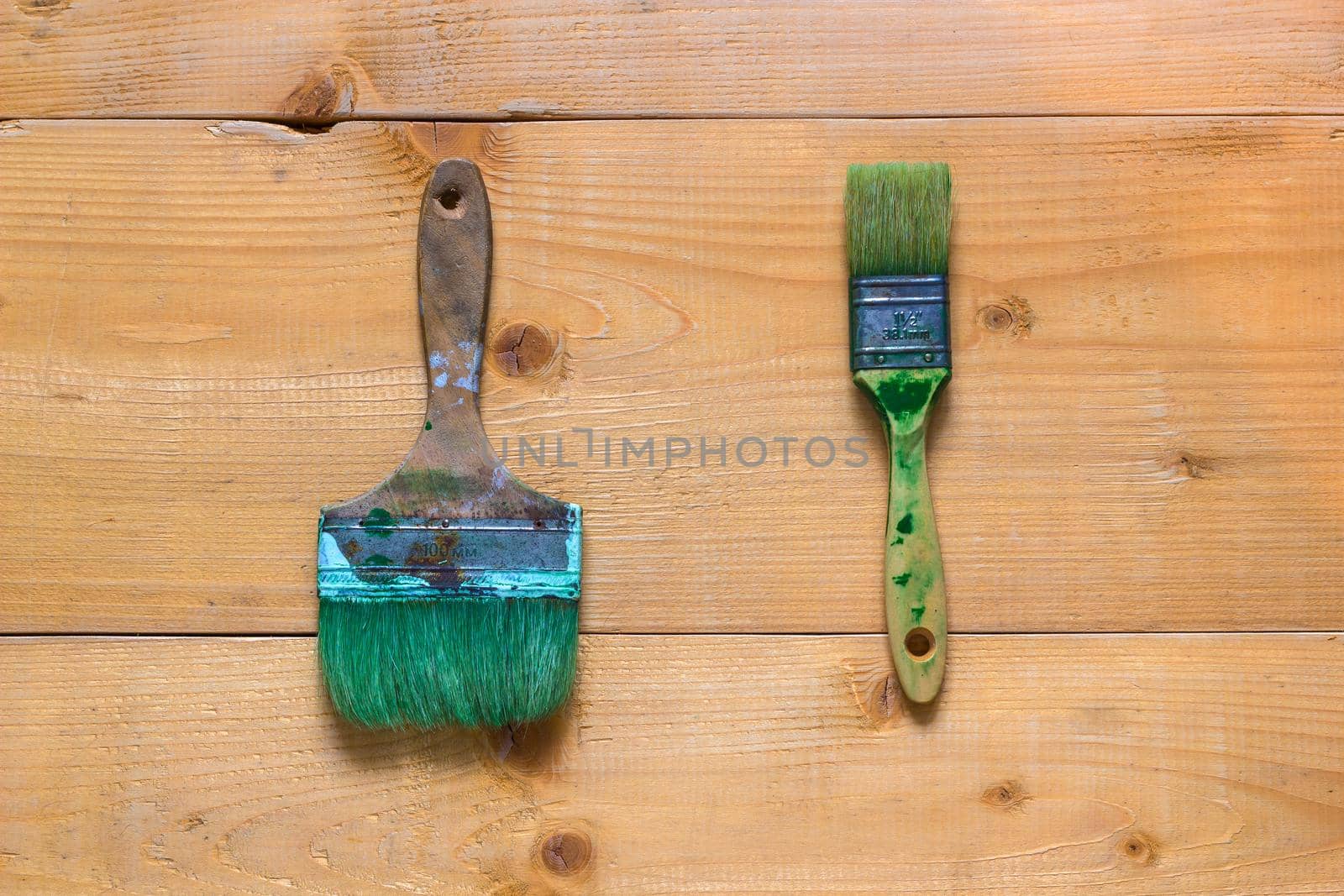 Used brushes on raw wood board surface. Flat view from top.