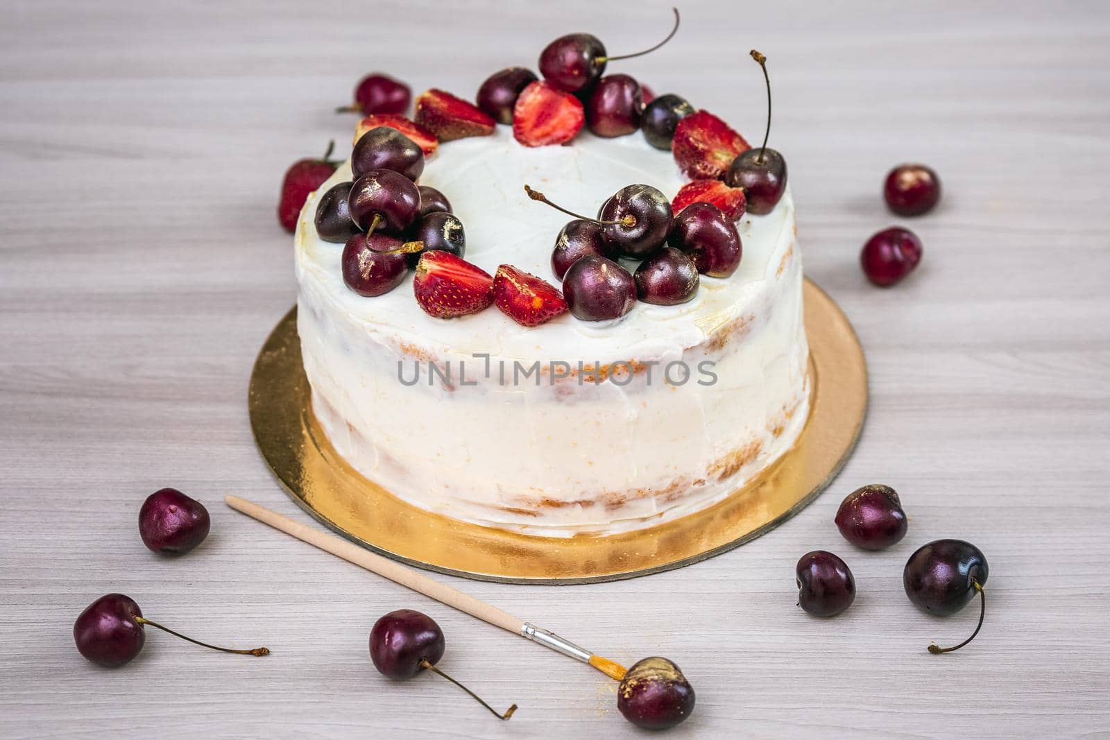 Cherries and strawberries with edible gold on top of cheesecake with coconut.