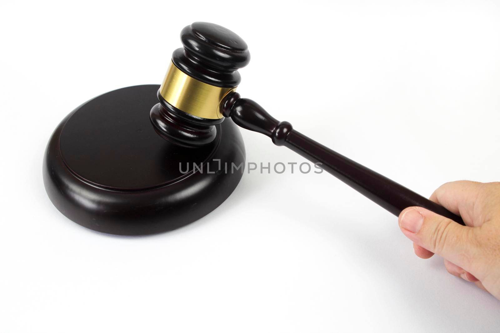 Hand holding a Wooden judge hammer on white background