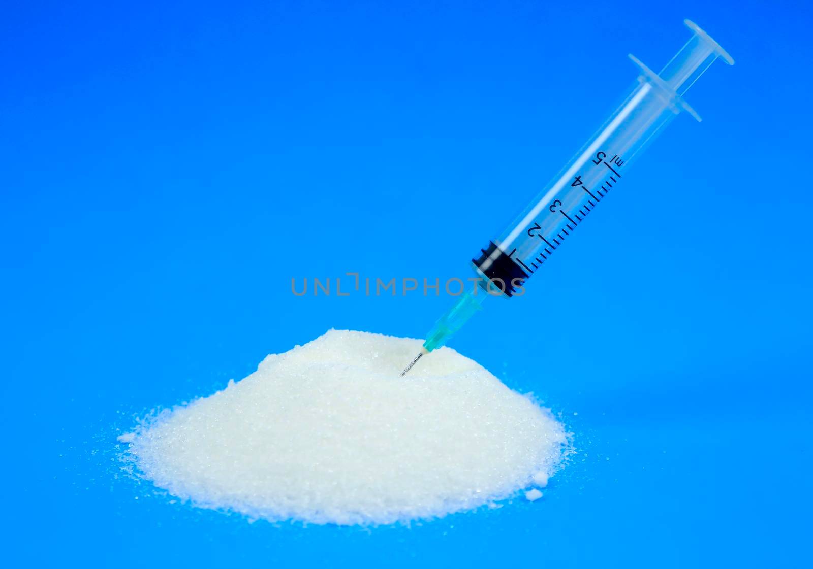 Conceptual photo of syringe and sugar emulating sugar addiction
