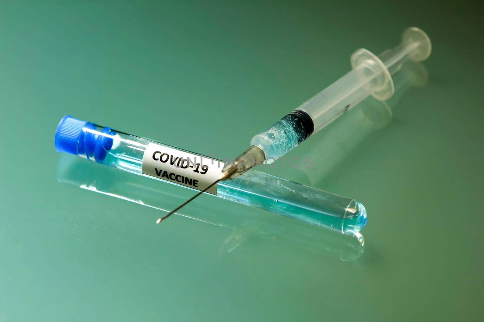 Syringe next to test tube with vaccine for Covid-19 virus