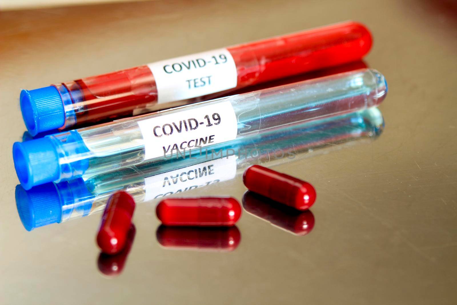 Red capsules and test tubes with blood and vaccine for Covid-19 virus