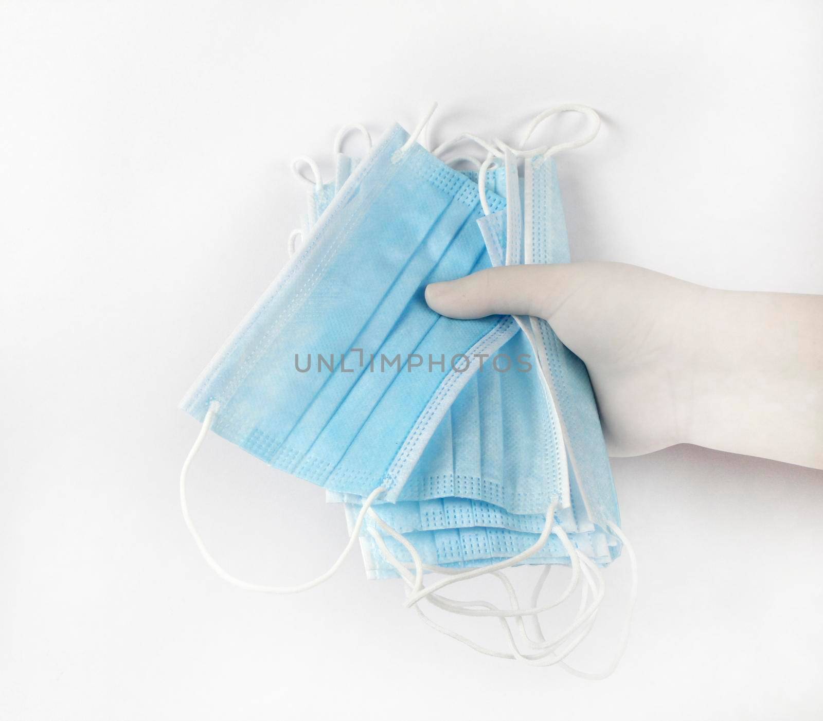 Hand on surgical gloves hanging Disposable Medical masks on white background. Covid-19 and healthcare concept