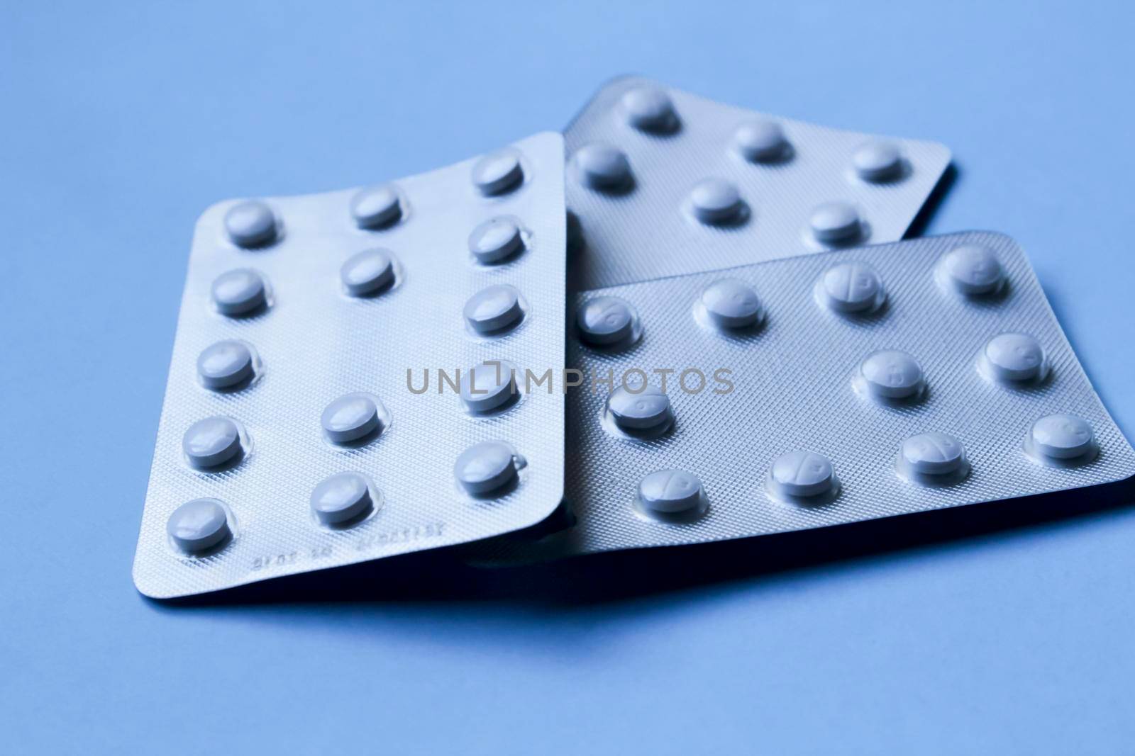 White pill blister packs on blue background
