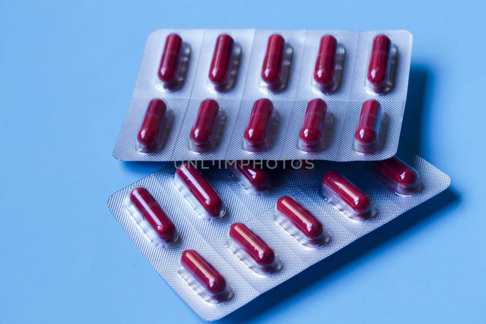 Red capsules blister packs on blue background