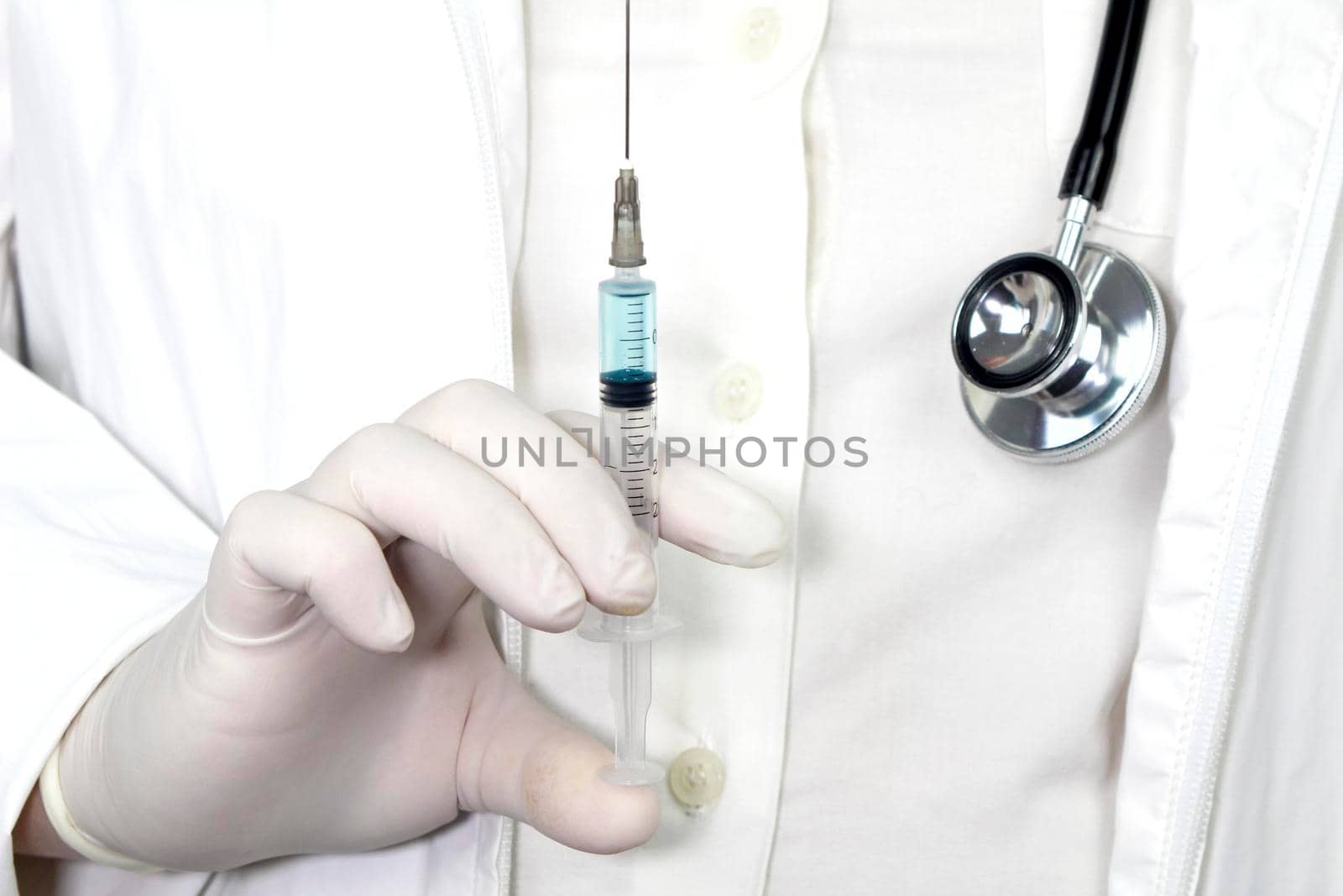 Medical professional on white uniform and surgery gloves holding a syringe with Covid-19 virus vaccine