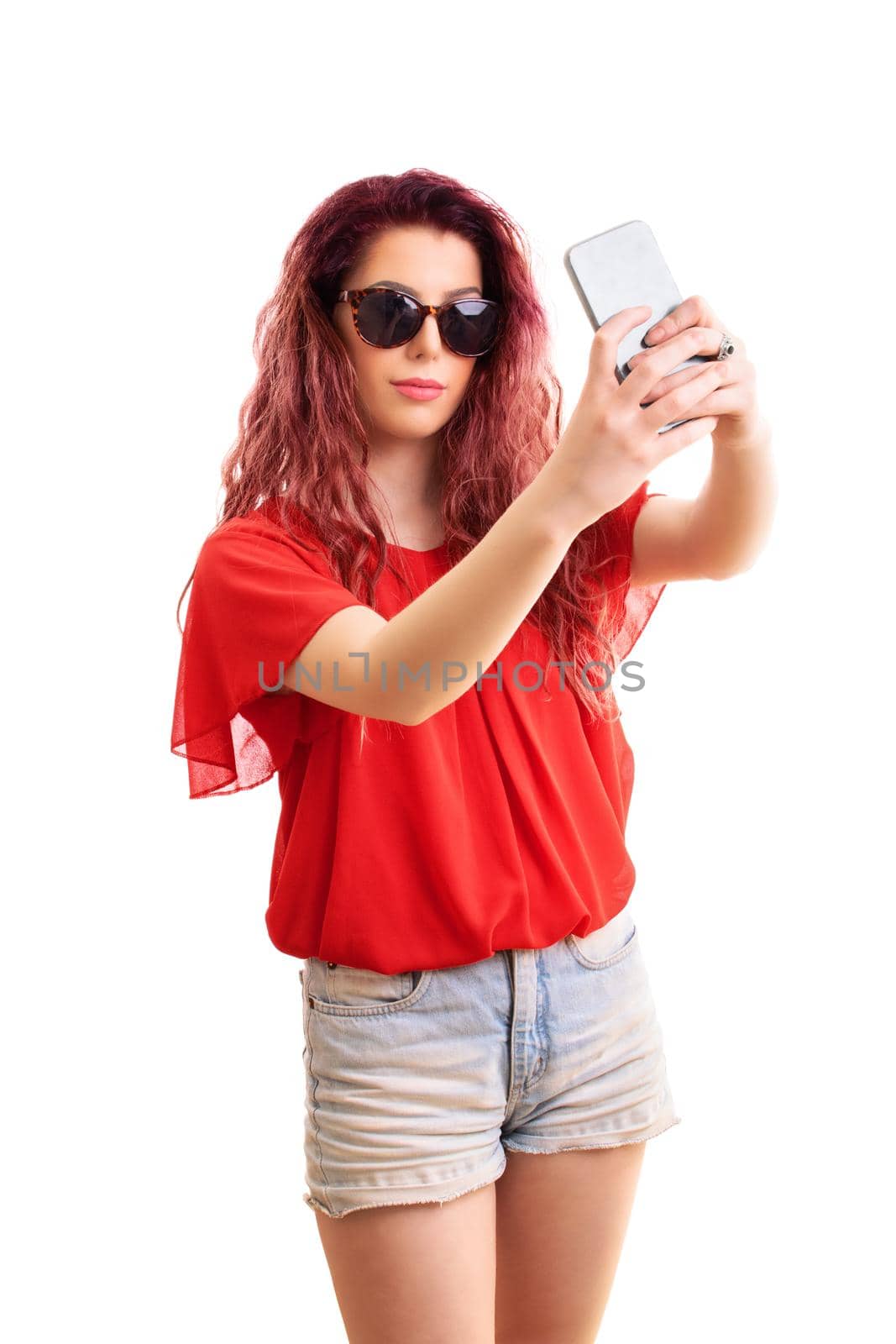 Fashionable young woman with sunglasses taking a selfie by Mendelex