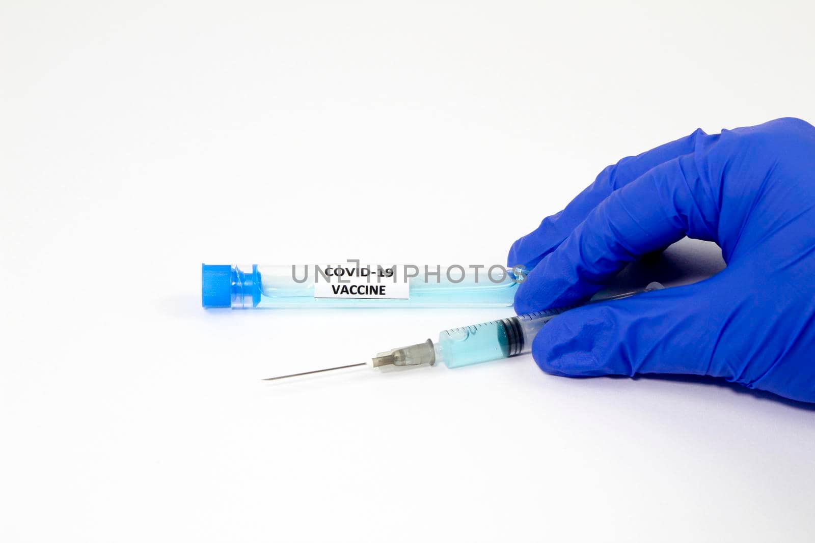 Medical professional hand with surgery glove holding a syringe with Covid-19 virus vaccine
