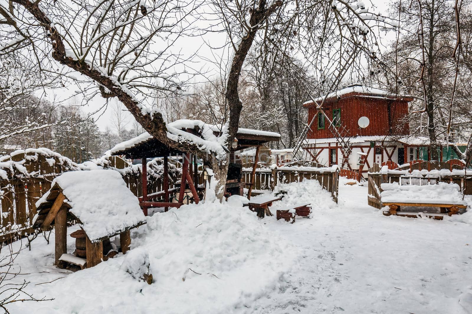 Decorated wooden house with textured wall covered with a heavy snow in the village in Belarus.