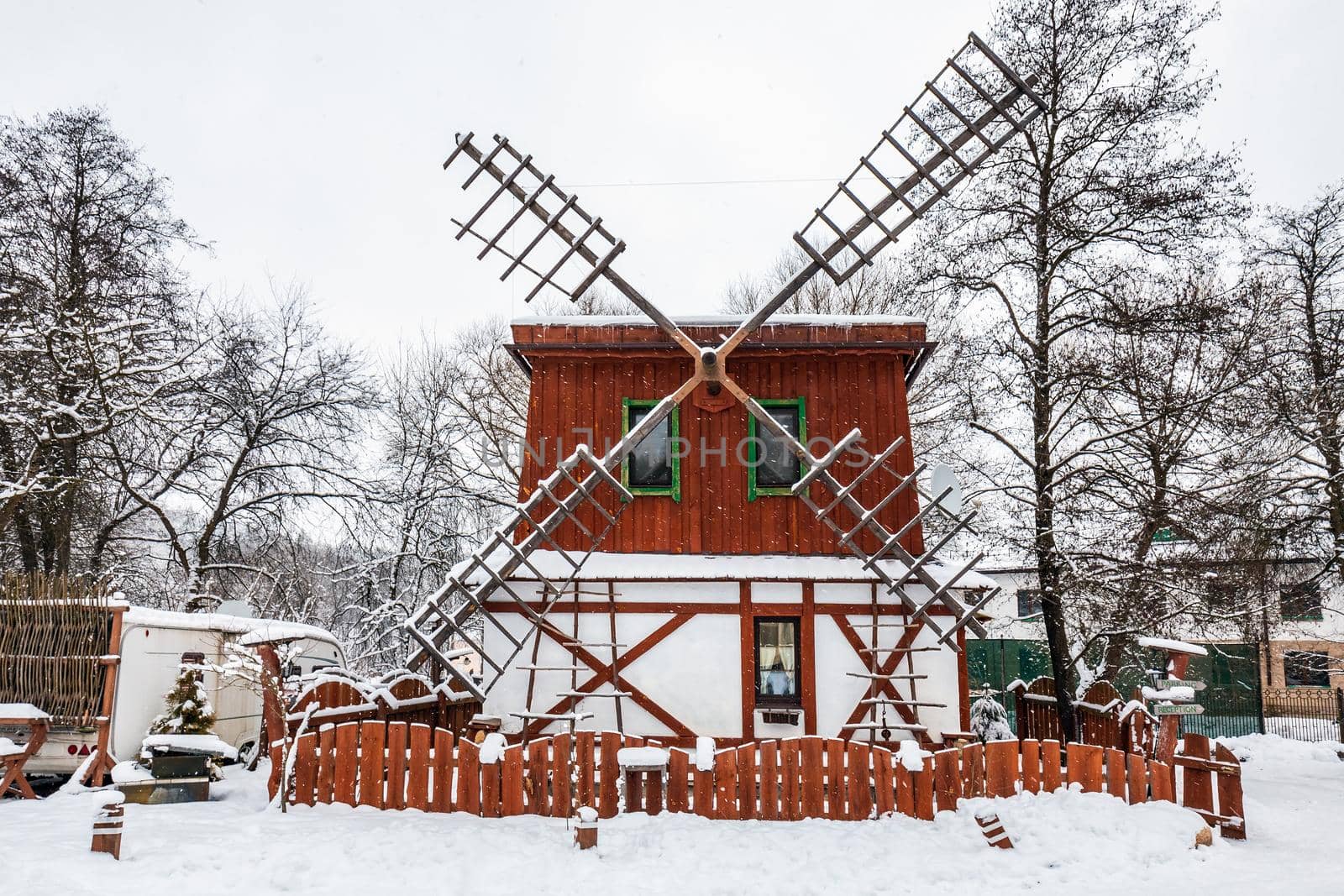Decorated wooden mill with textured wall covered with a heavy snow in the village in Belarus.