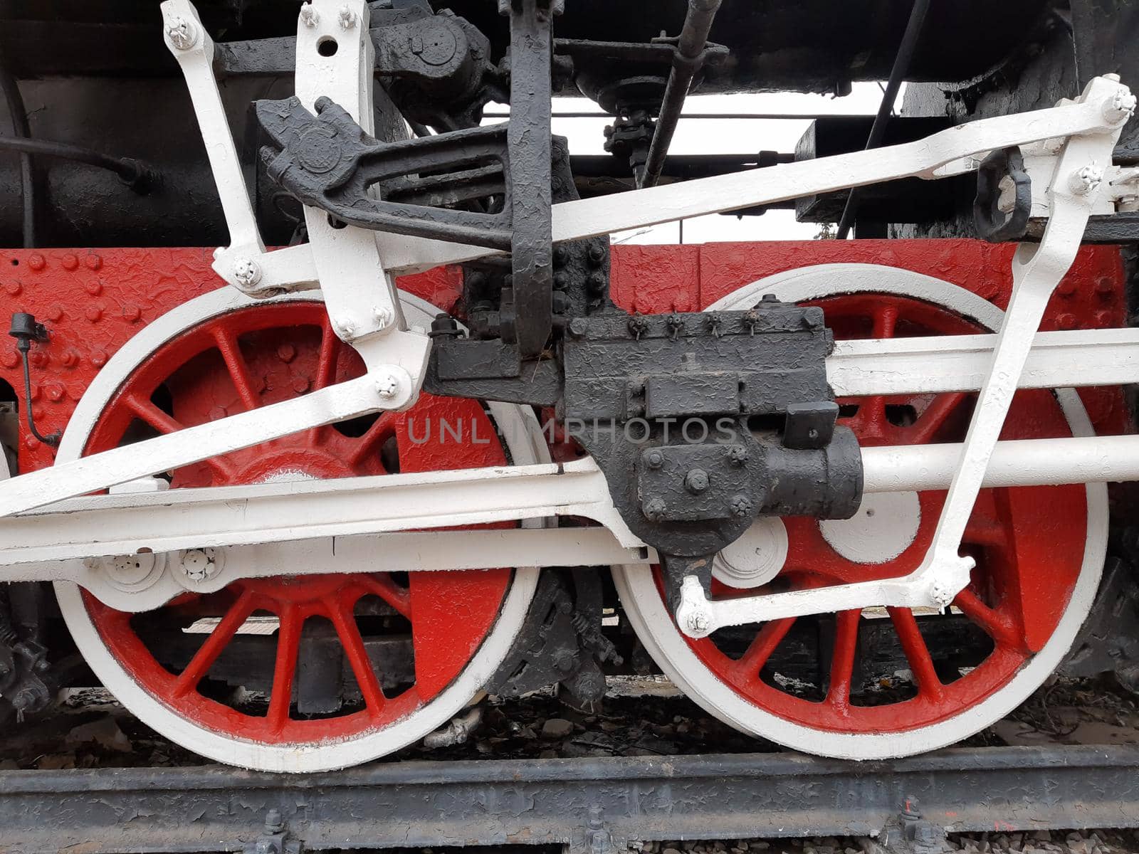 Wheels of an old steam locomotive on rails close-up.