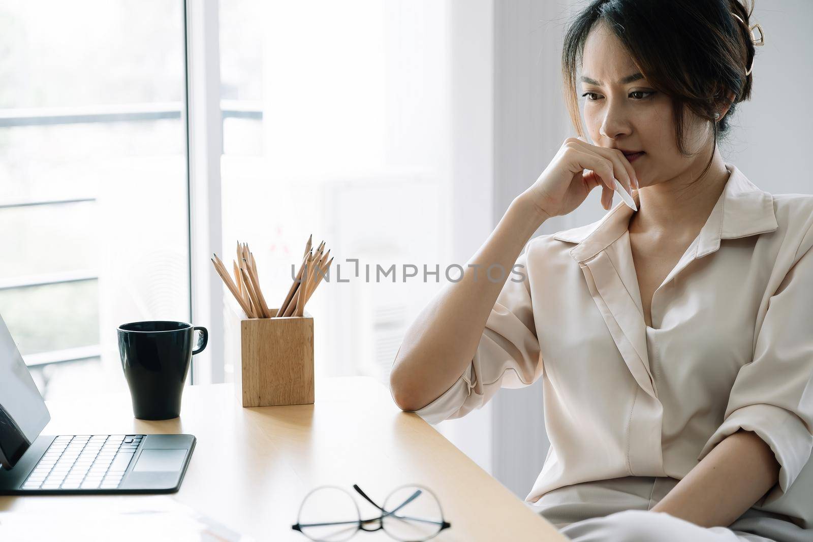 Portrait Young asian businesswoman thinking for work at her office