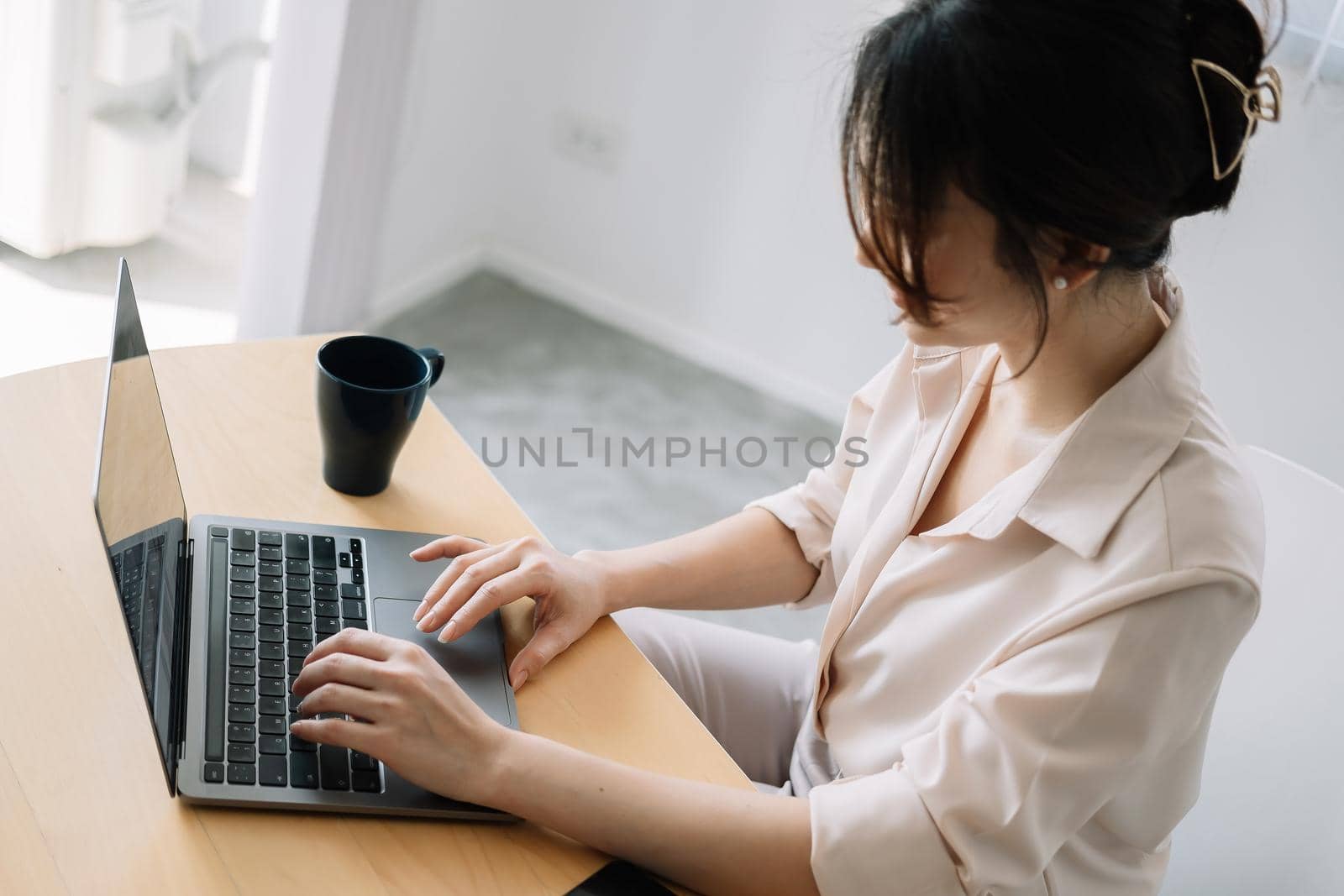 Young asian businesswoman sitting front open portable laptop computer reading email from client, long hours of work concept. by nateemee