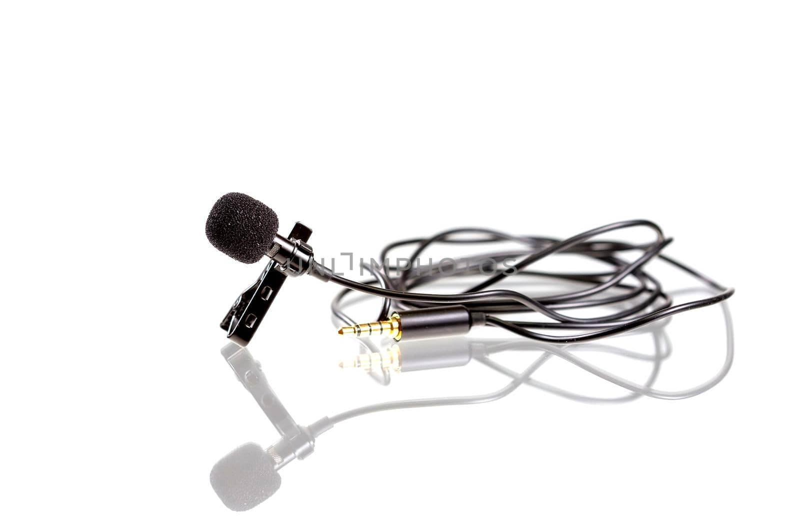 Small lavalier microphone or lapel mic with clip on white background. Professional sound recording equipment for cell phone.