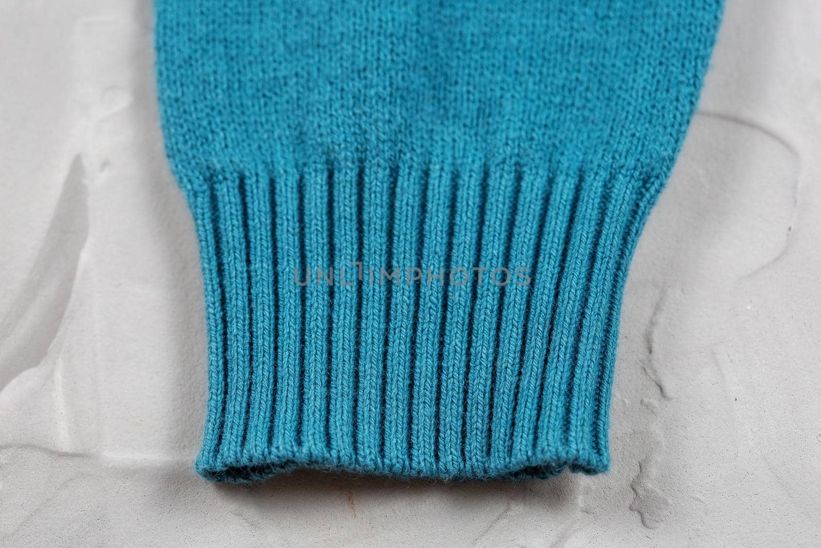 Close-up of knitted elastic blue sweater cuff.