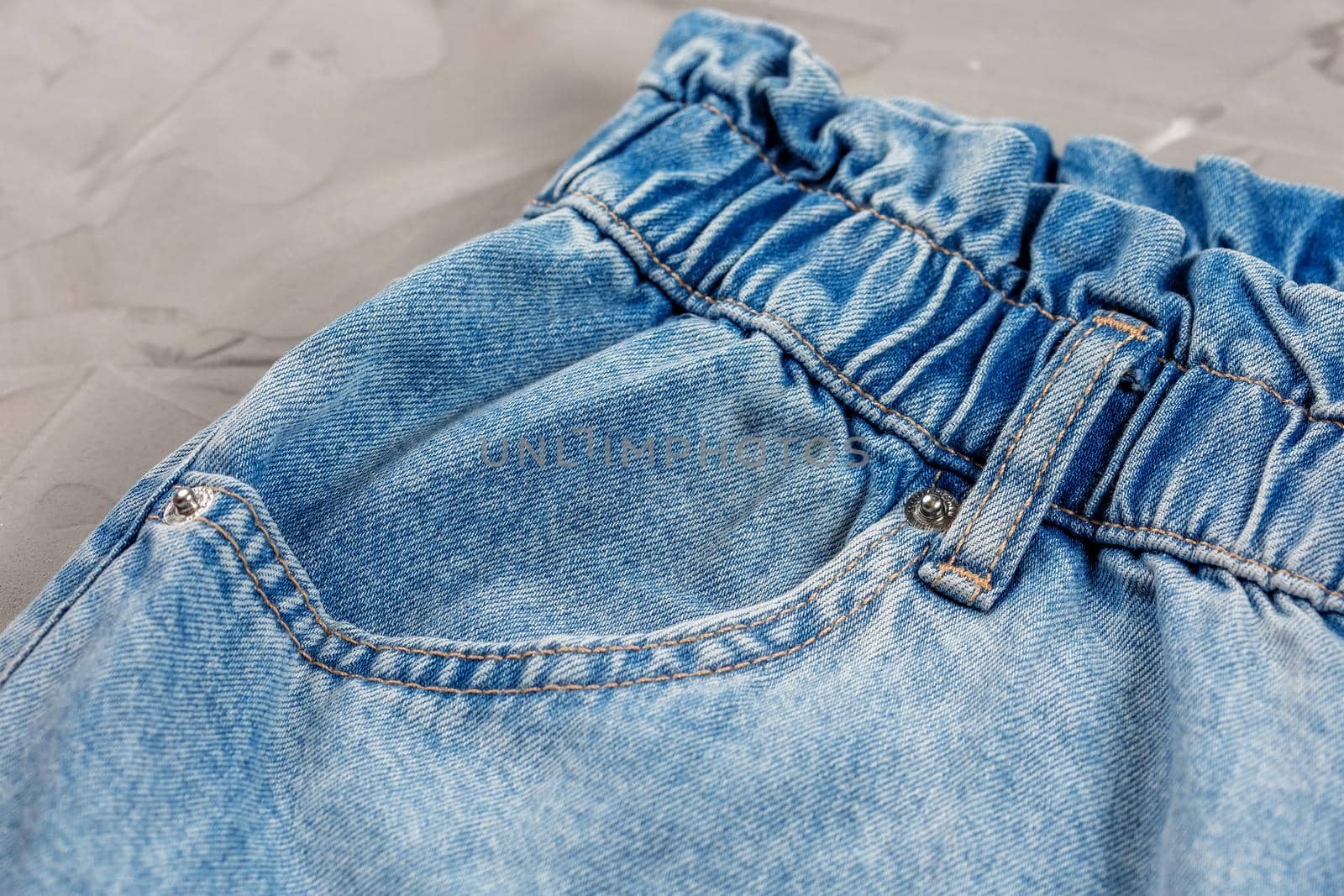 Close-up of blue jeans pocket showing fabric texture and stitching.