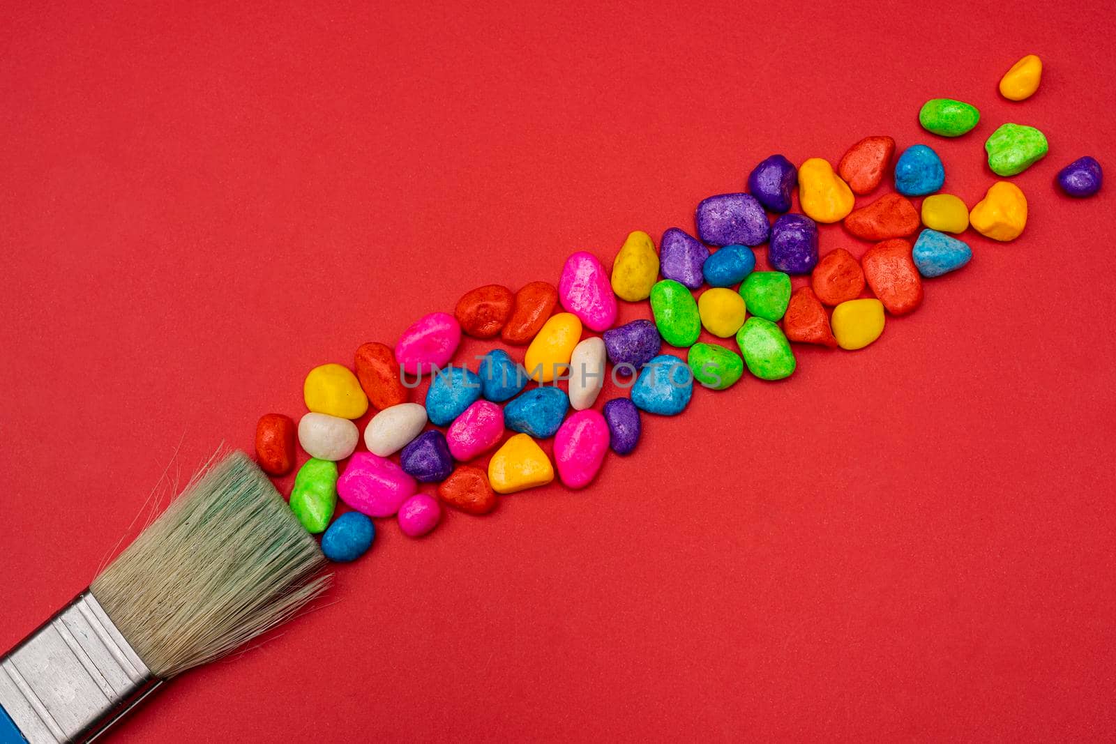 a brush leaves a trail of colored pebbles