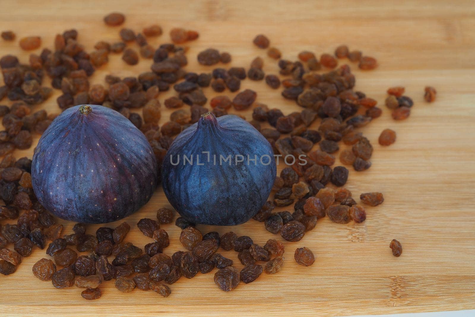 Ripe figs and brown raisins, close-up, natural products. by Olga26