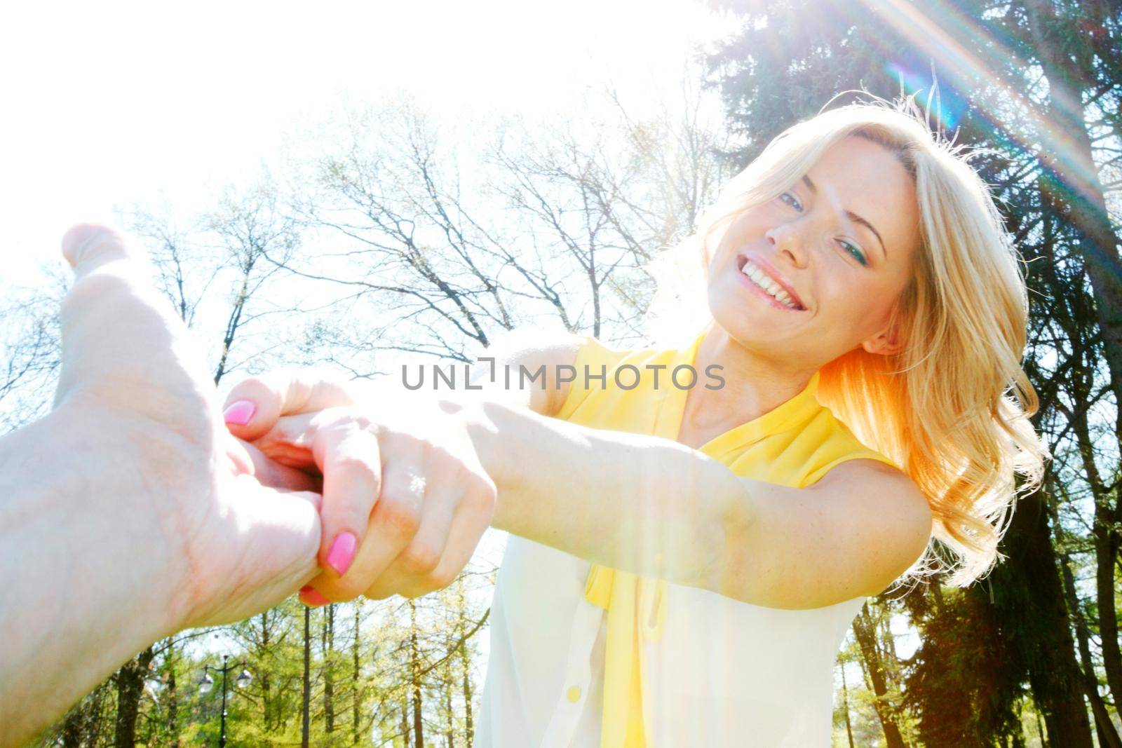 Happy woman holding by hands and whirling in park