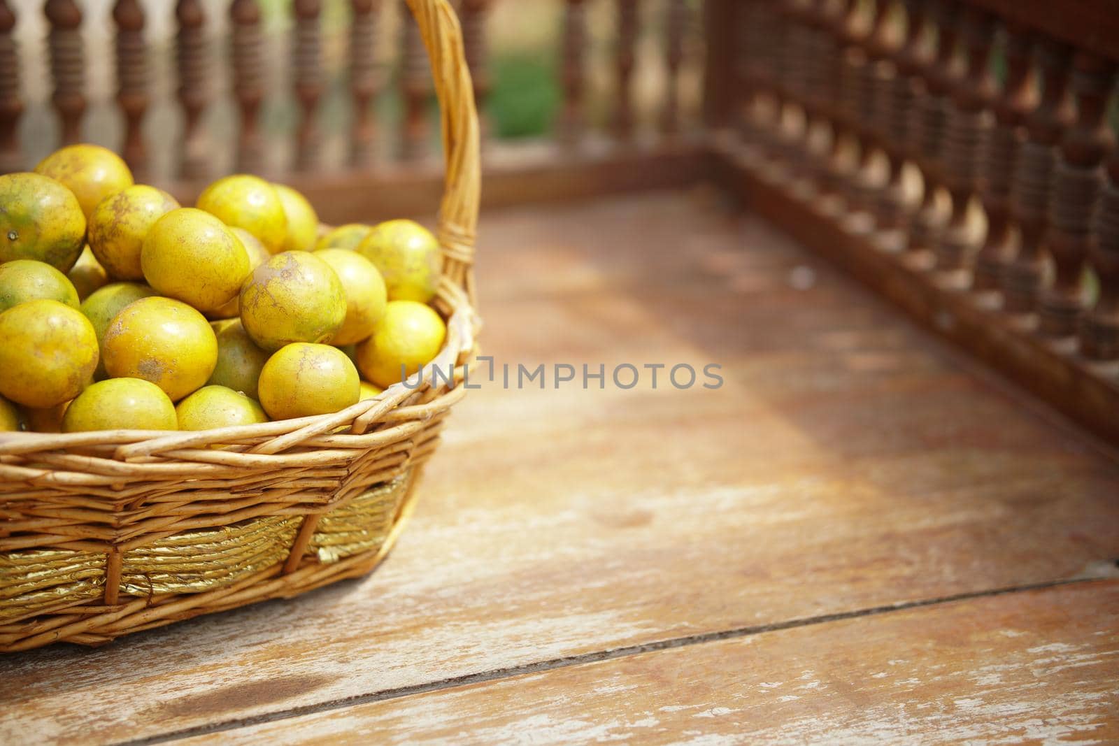 fresh orange tangerine fruit in rattan wicker basket on wooden chair
