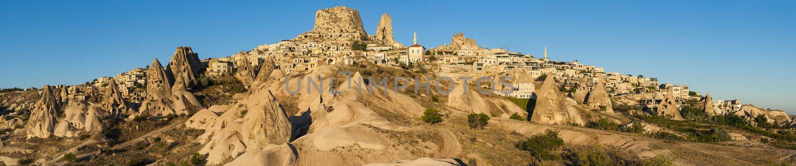 Ancient town and a castle of Uchisar dug from a mountains after sunrise, Cappadocia, Turkey.Panorama