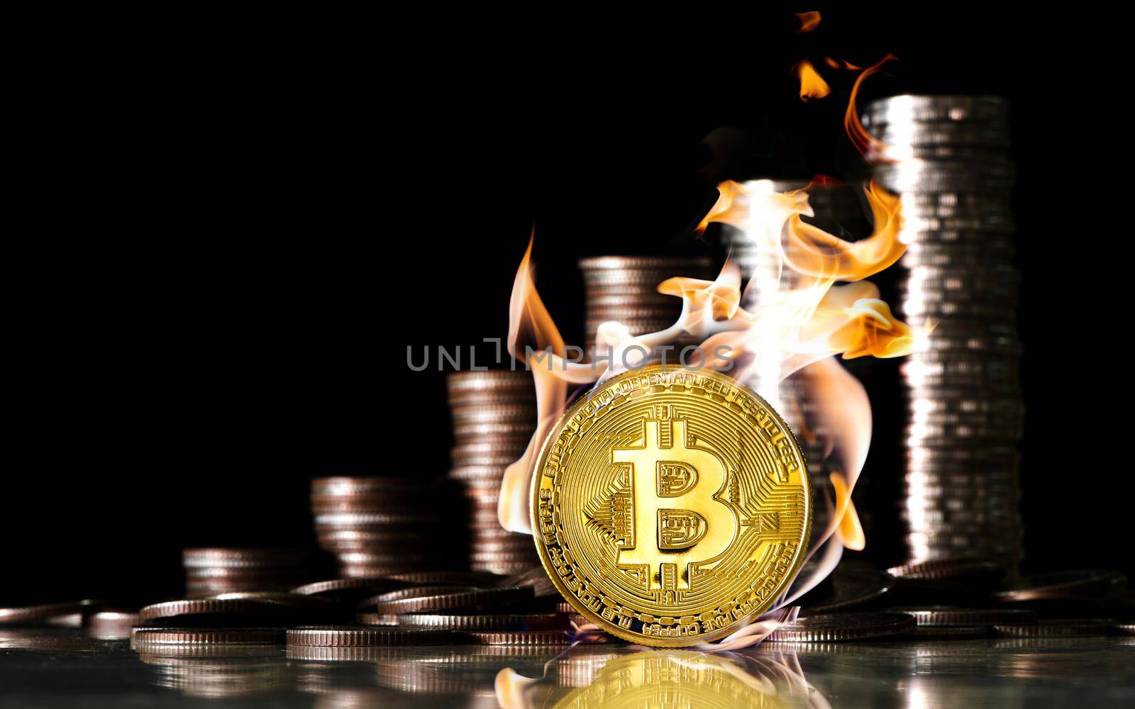 Bitcoin inside the fire on the background of coins of baht. Finance and investment concept.