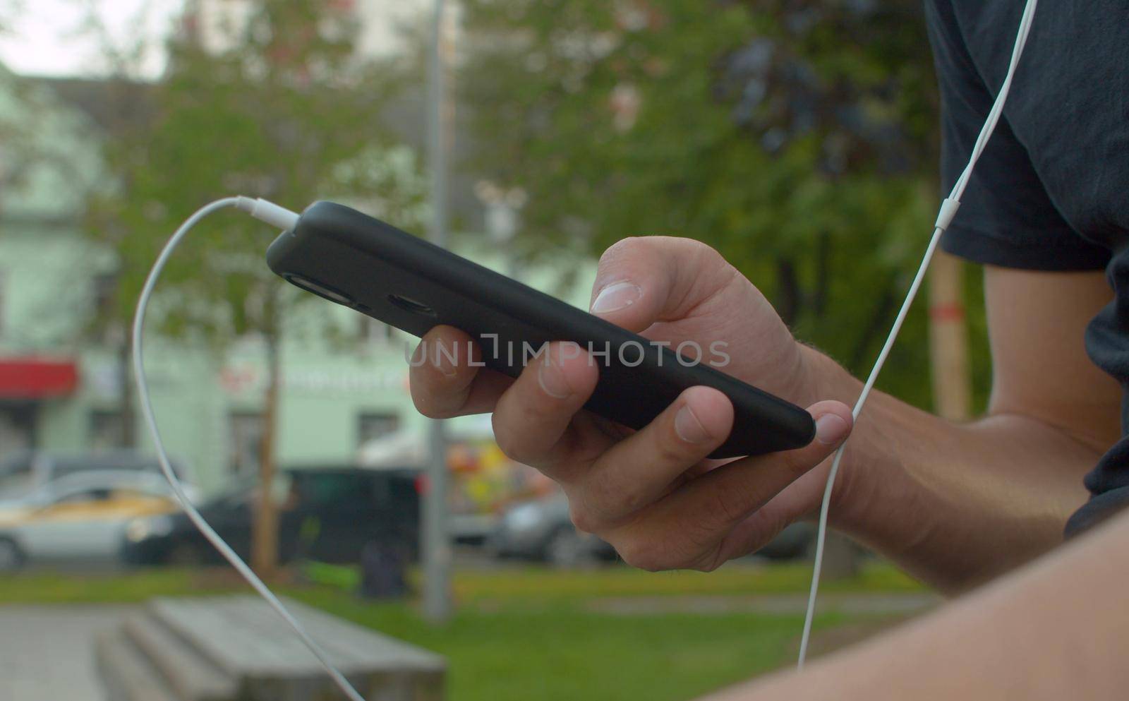 Hand of a man scrolling smart phone by Chudakov