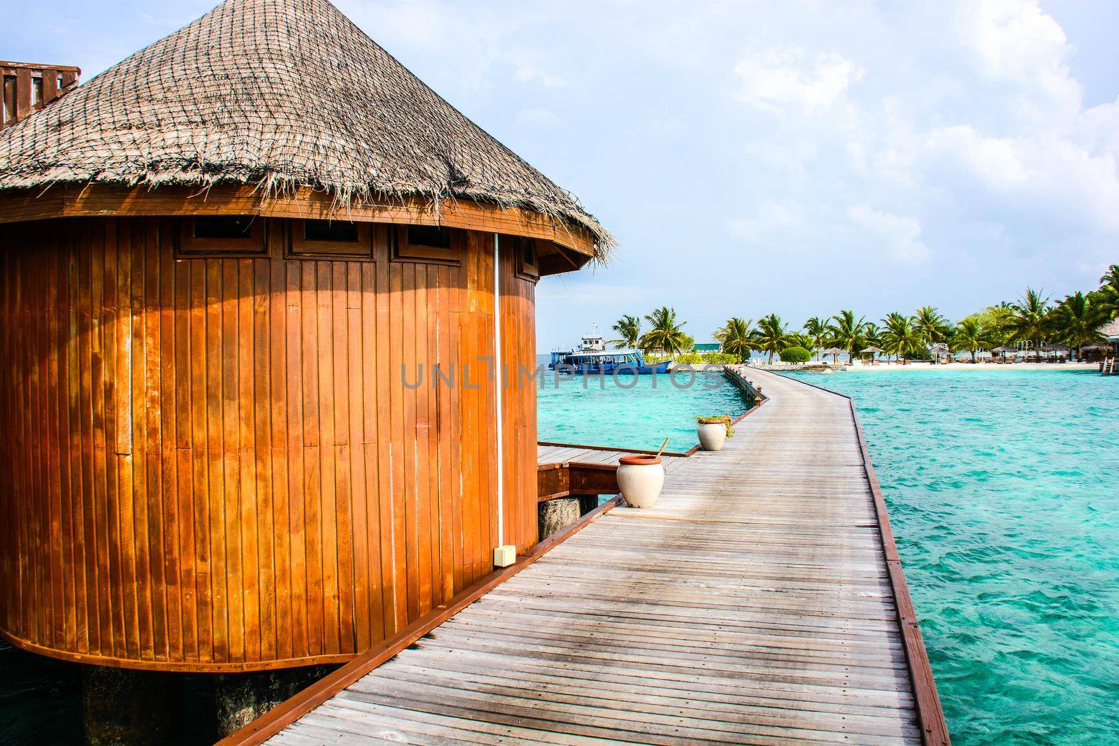 atoll of the tropics and maldives that are reflected in a sea of emerald with a cobalt blue sky