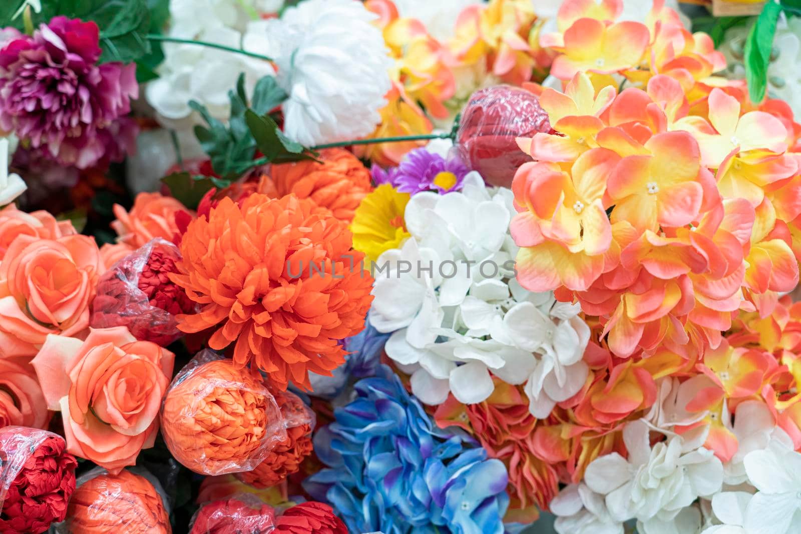 artificial multicolored flowers close up as background. High quality photo