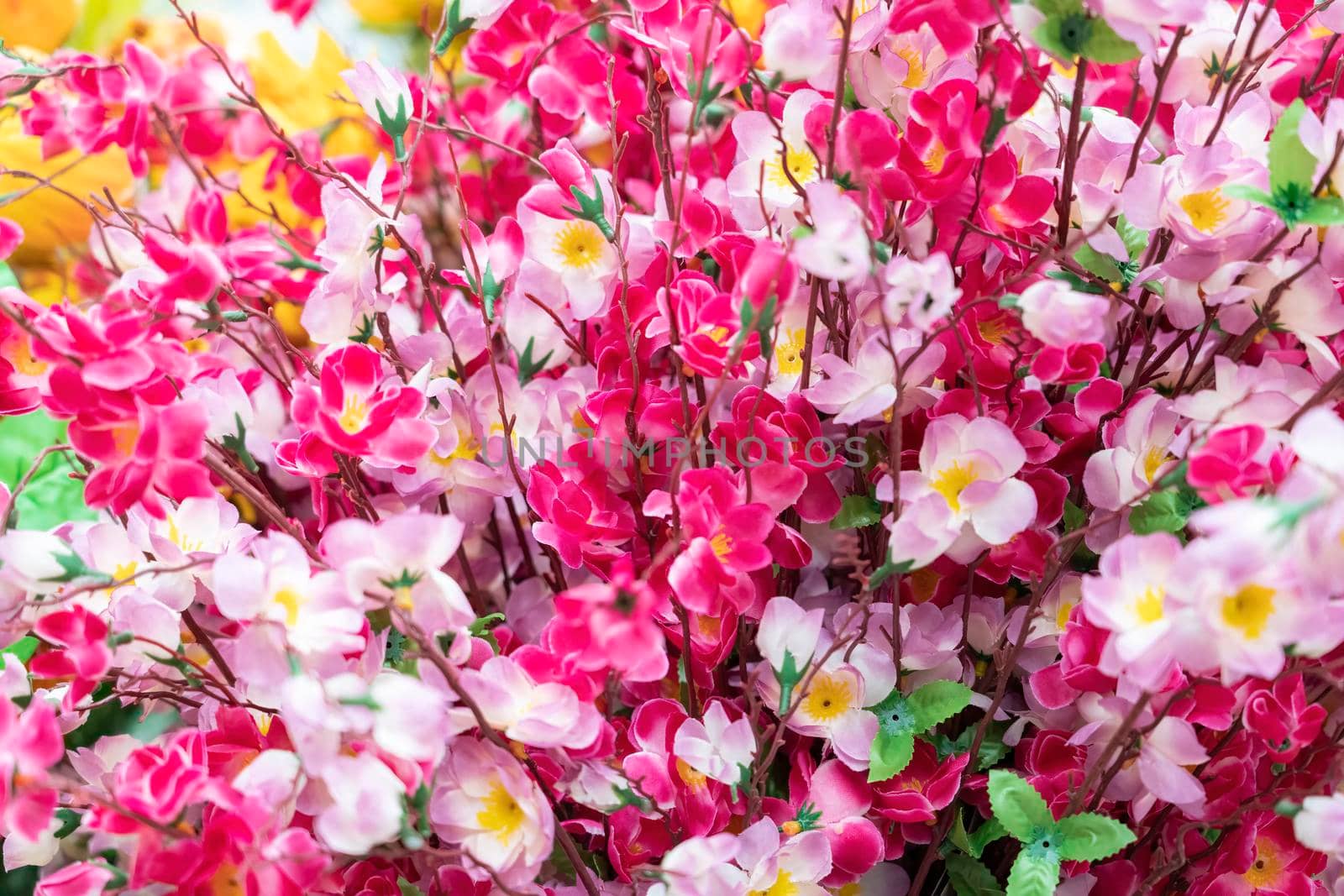 artificial multicolored flowers close up as background. High quality photo