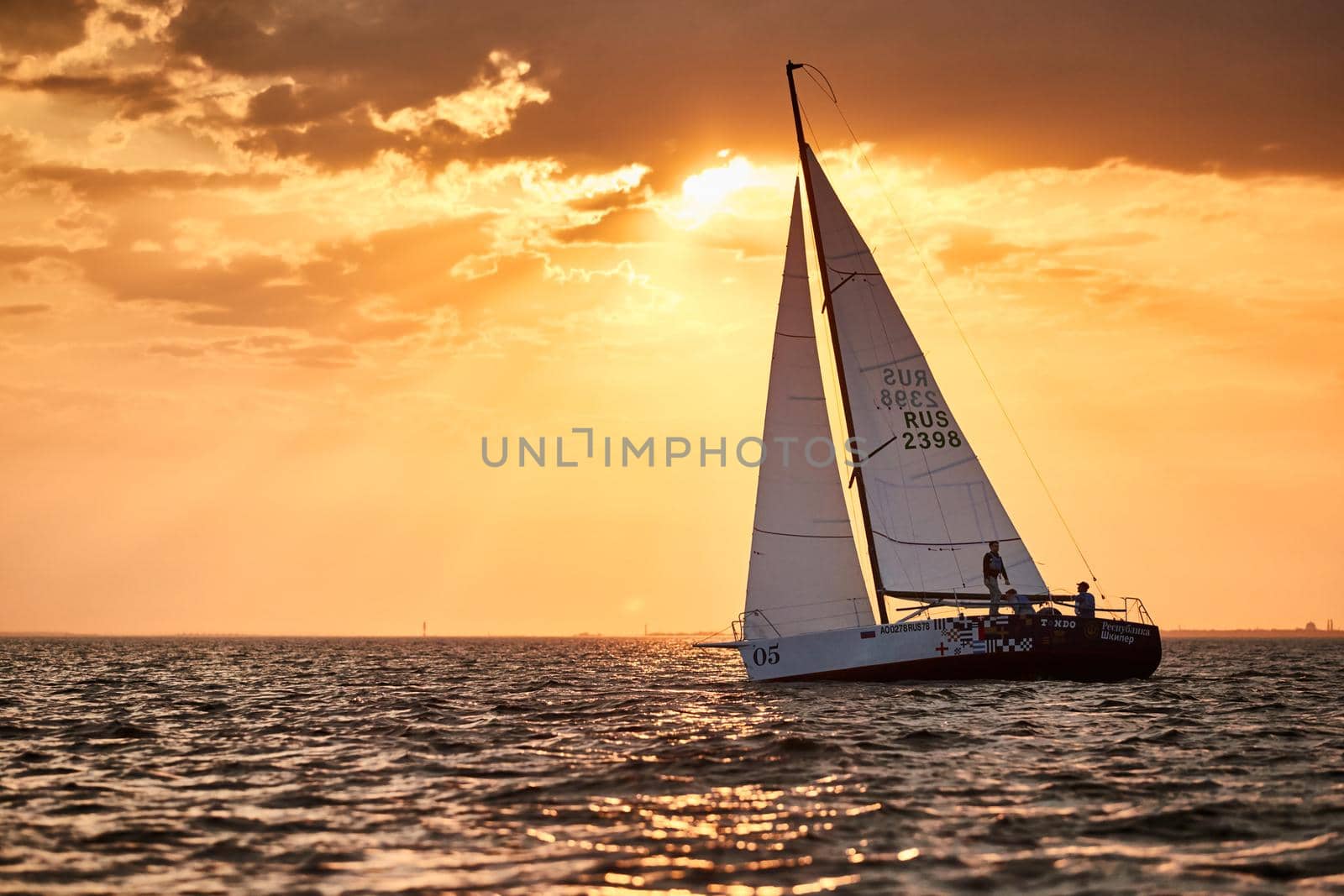 Russia, St.Petersburg, 05 September 2020: The lonely sailboat in a list goes by sea, the sky of pink color, the storm sky. High quality photo
