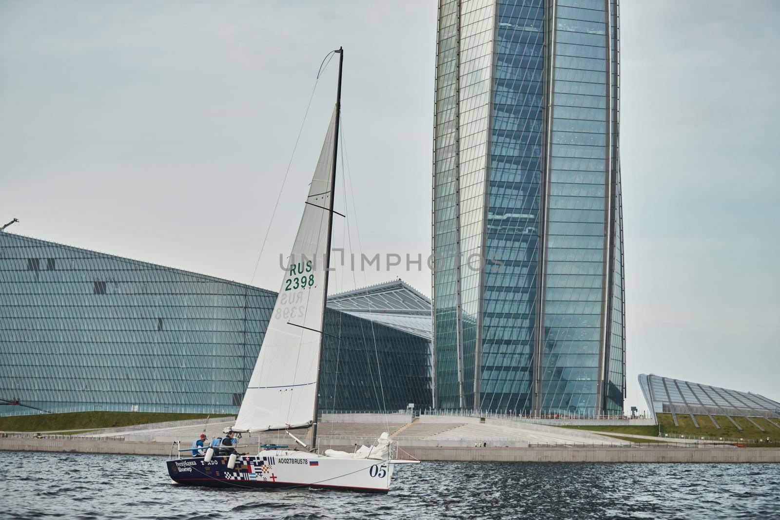 Russia, St.Petersburg, 05 September 2020: Sailing sport boat against the highest skyscraper in Europe the oil company Gazprom, Lakhta Center, is a lot of metal and glass, stand in yacht club. High quality photo