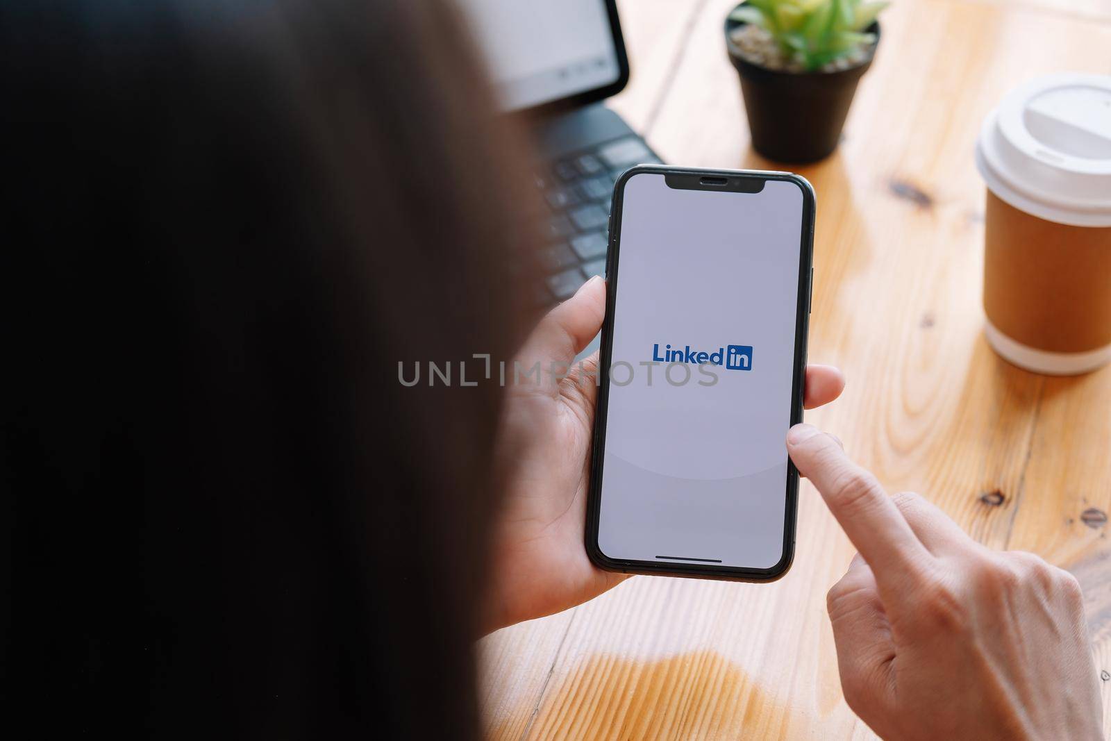 CHIANG MAI, THAILAND, MAR 21, 2021 : A women holds Apple iPhone Xs with LinkedIn application on the screen.LinkedIn is a photo-sharing app for smartphones.