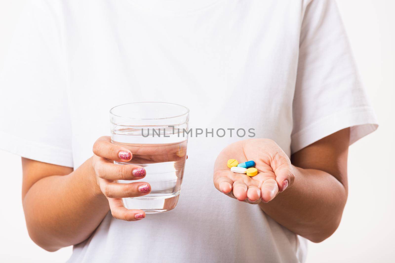 Closeup young Asian woman hold pill drugs in hand ready take medicines with a glass of water, studio shot isolated on white background, Healthcare and medical pharmacy concept