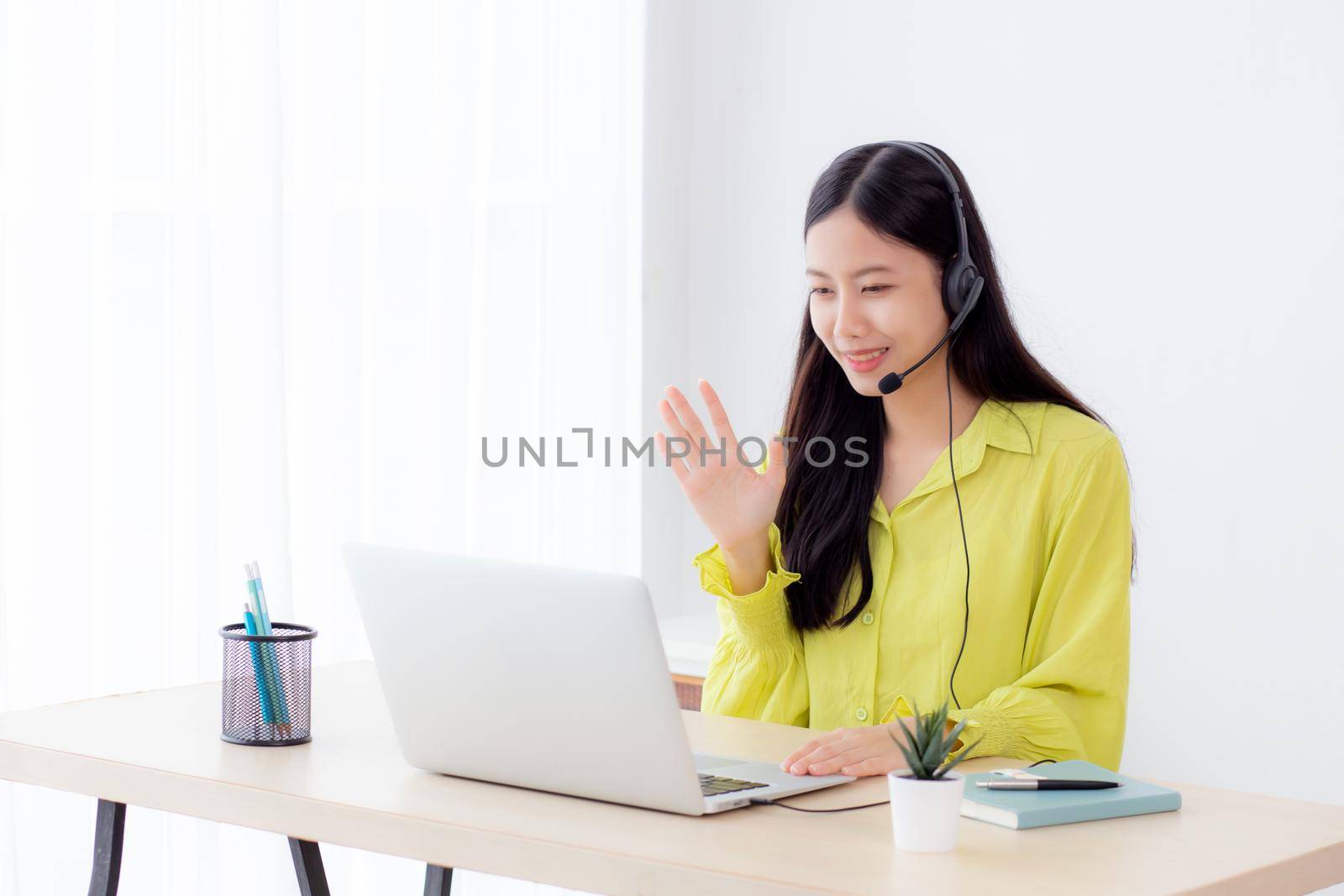 Young asian business woman using laptop computer for video conference online with social distancing, businesswoman working with video call, new normal, communication and work from home concept.