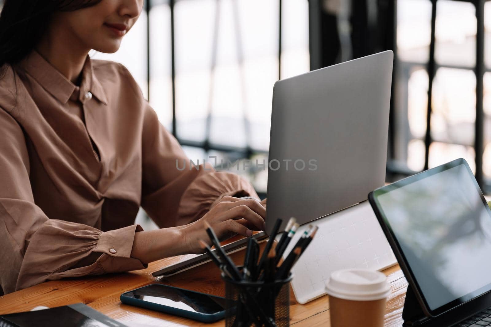 Young asian business woman working on laptop in office. by nateemee