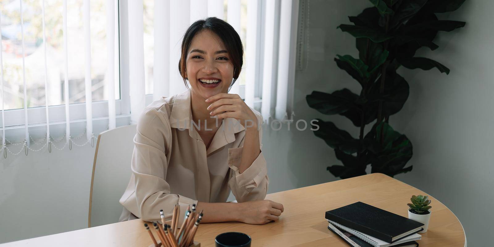 Portrait of beautiful Asian girl smiling happy pose at her office
