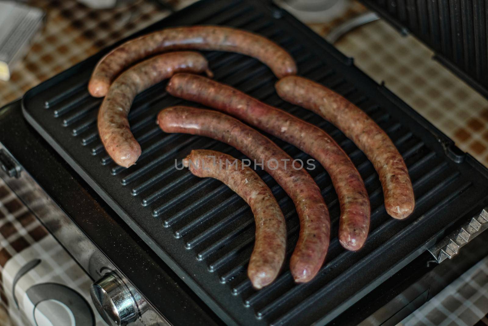 Grilled raw sausages are cooked, close up shot