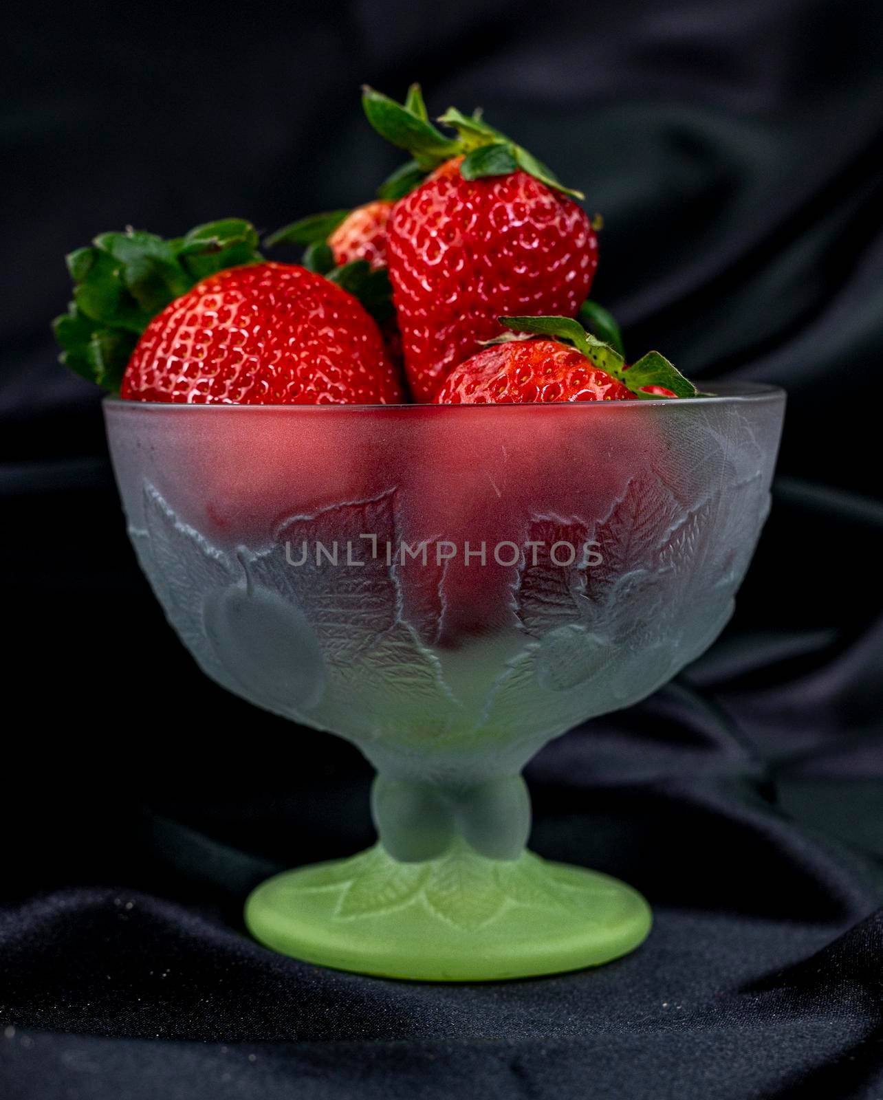 cup of ripe strawberries on black background by carfedeph