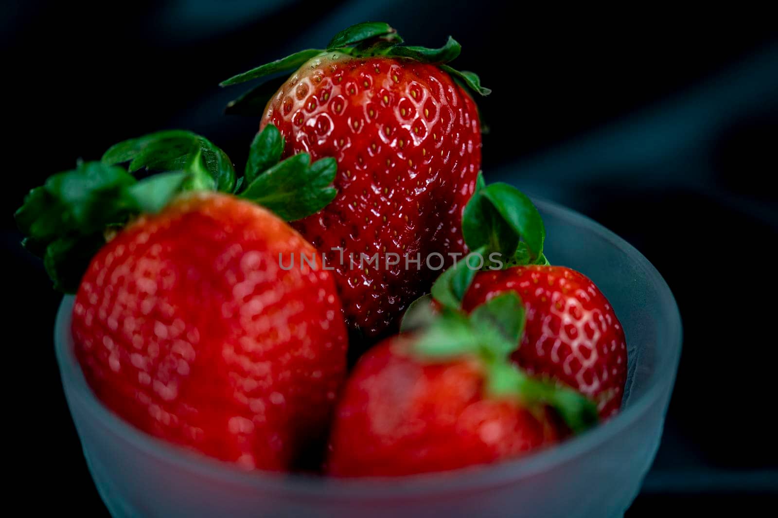 cup of ripe strawberries on black background by carfedeph