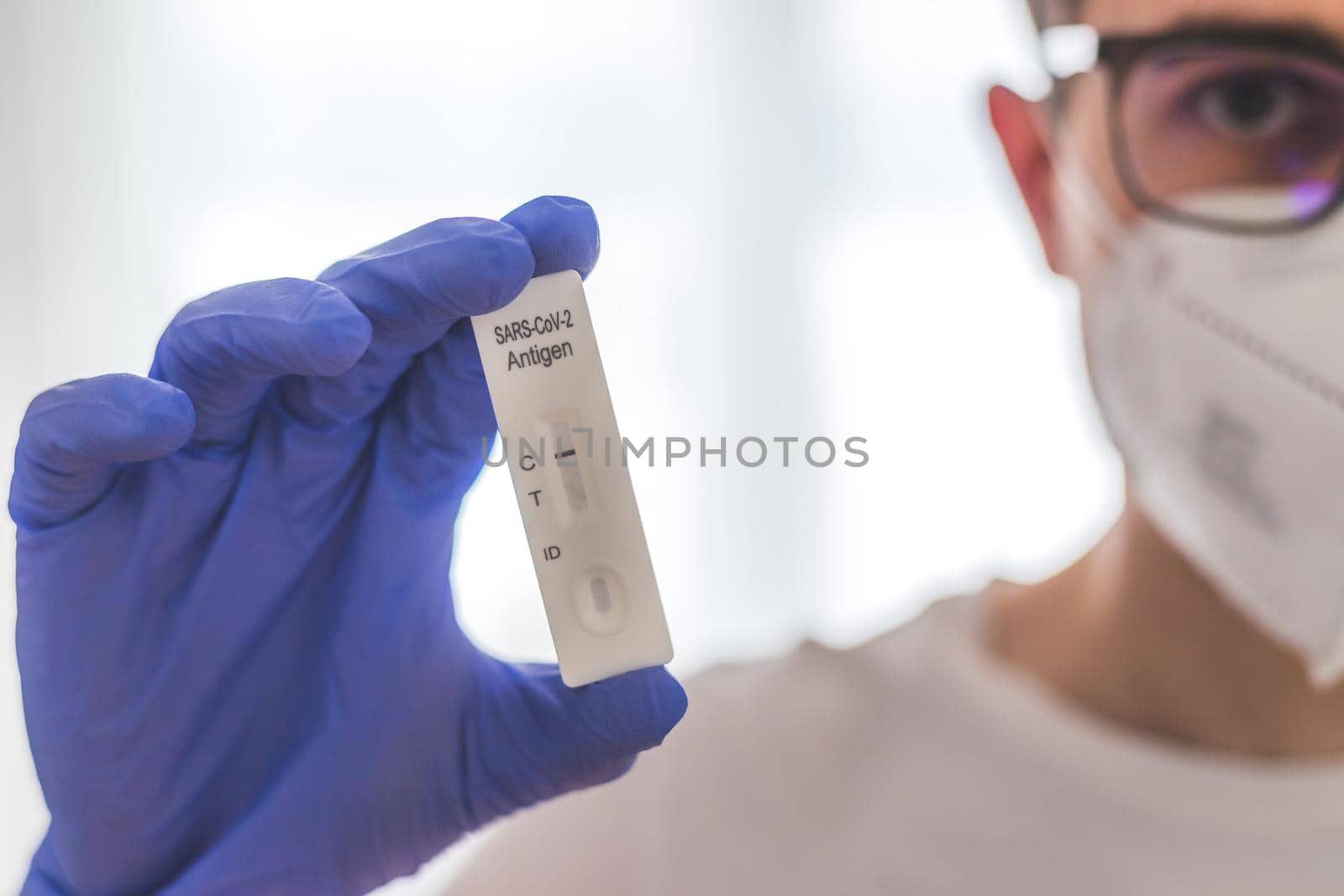 Young biologist or pharmacist is holding a covid-19 or corona antigen test by Daxenbichler