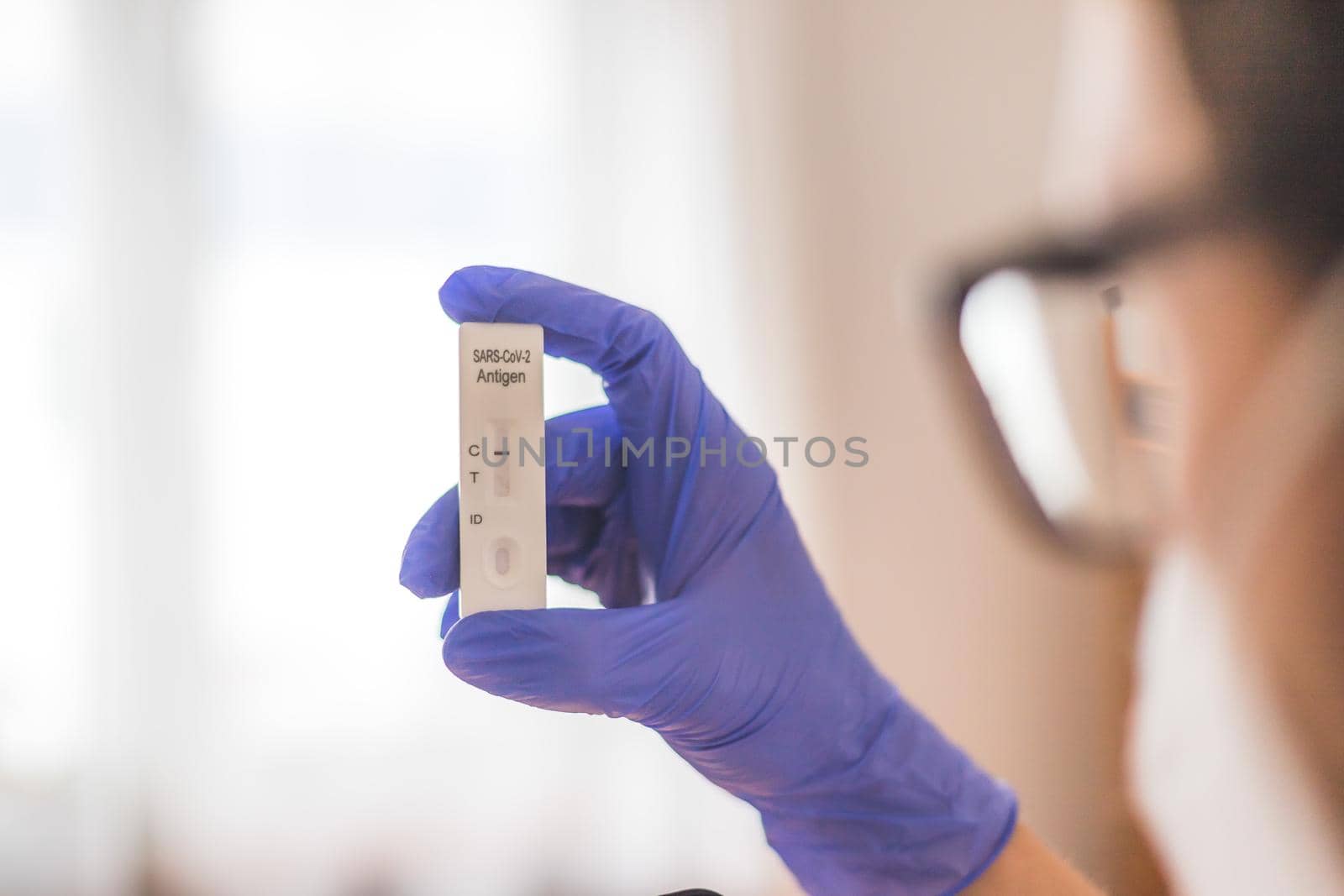 Young biologist or pharmacist is holding a covid-19 or corona antigen test by Daxenbichler