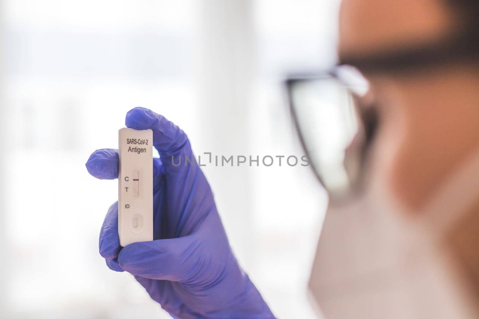 Young biologist or pharmacist is holding a covid-19 or corona antigen test by Daxenbichler