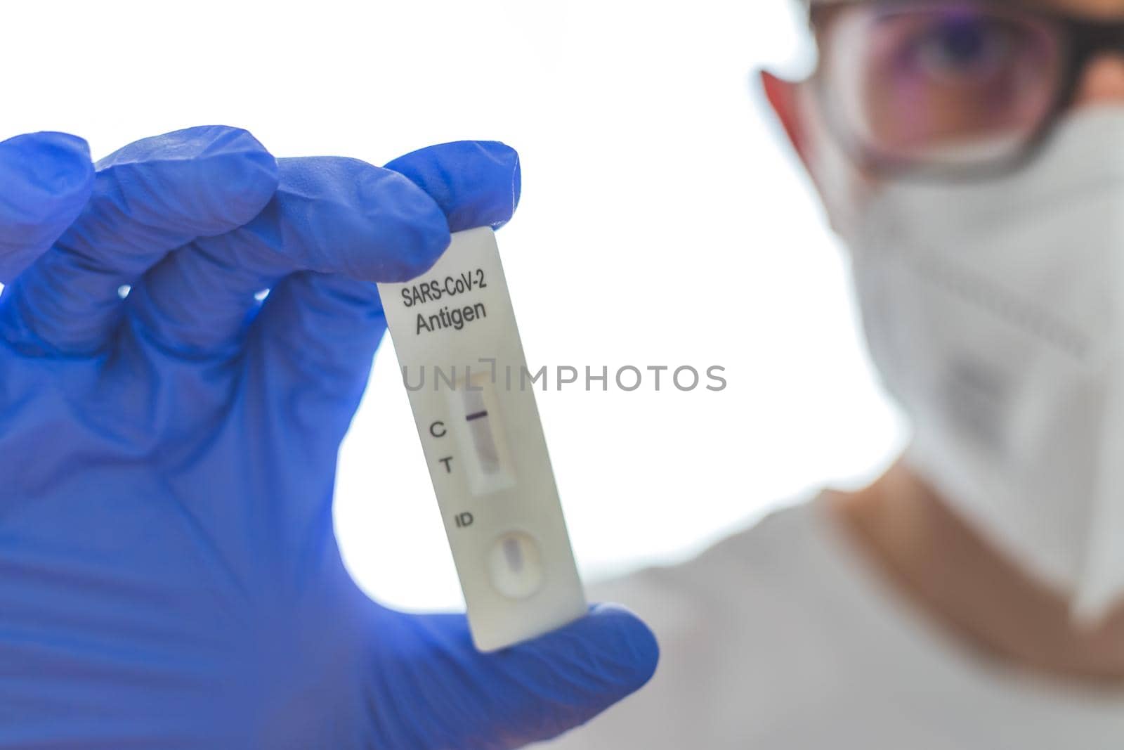 Close up of antigen corona or covid-19 test in the fingers of a young biologist or pharmacist
